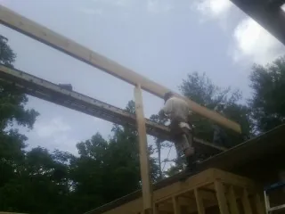 Carpenter setting a ridge beam over a new addition frame — Ice Dam Removal by Roofing Brothers in Shickshinny