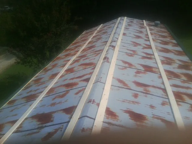 Rusted metal roof panels with new wood purlins before replacement — Storm Damage Roof Repair in Shickshinny by Roofing Brothers