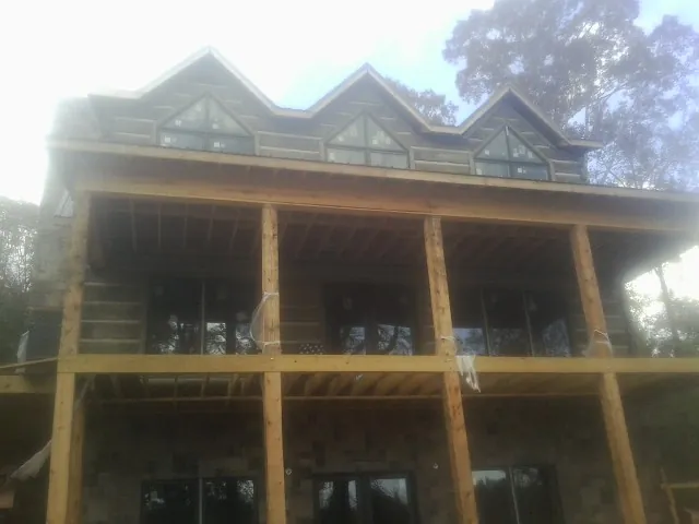 Dormers and porch framing on a large log home under construction — Roof Coating work by our crew in Shickshinny