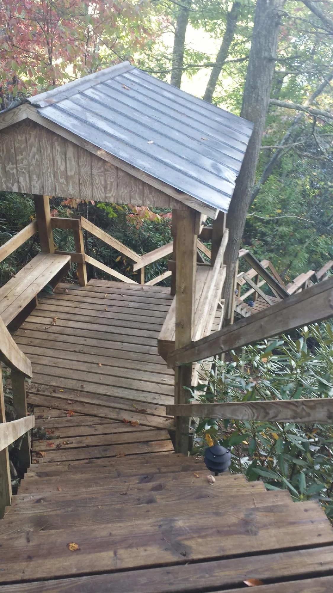 Metal roofed shelter over wooden steps on a wooded walkway — Skylight Repair & Installation work by our crew in Shickshinny