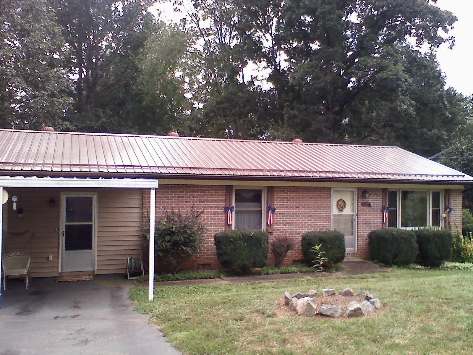 Bronze metal roof and carport on a brick ranch home — Roof Repair work by our crew in Shickshinny